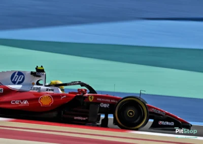 Vue latérale de la Ferrari SF-26 de Lewis Hamilton (n°44) frôlant les vibreurs colorés du circuit de Sakhir lors des essais 2026.