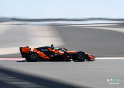Plan large de la McLaren MCL40 de Lando Norris (n°1) en pleine accélération sur la ligne droite du circuit de Bahreïn, avec un effet de vitesse sur l'arrière-plan.