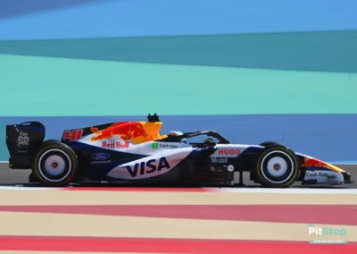 Profil complet de la Racing Bulls VCARB RB03 d'Arvid Lindblad en piste à Bahreïn sur fond de bandes colorées.