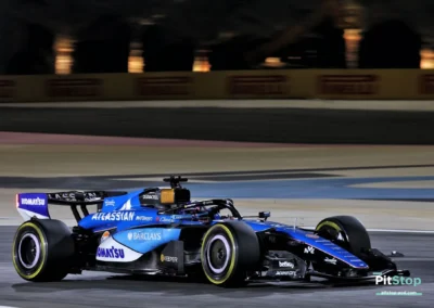 La Williams FW48 d'Alex Albon en action de nuit sur le circuit de Sakhir, avec les lumières des projecteurs se reflétant sur la carrosserie bleue.