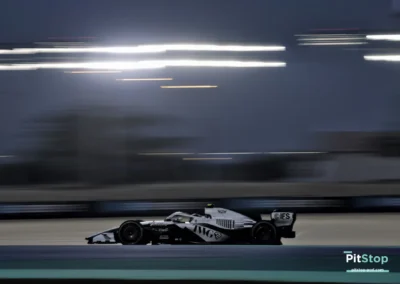 Plan large de la Cadillac F1 de Valtteri Bottas de profil, roulant de nuit sous les projecteurs du circuit de Bahreïn.