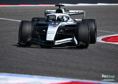 Vue de face de Sergio Perez au volant de la Cadillac F1 n°11 négociant un virage à Bahreïn, livrée noire et blanche.