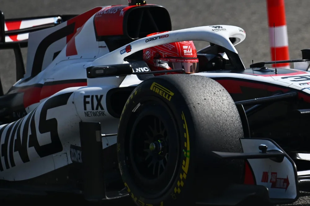 Gros plan sur Esteban Ocon au volant de la Haas VF-26 lors des essais de présaison, montrant les détails du cockpit et du casque rouge.