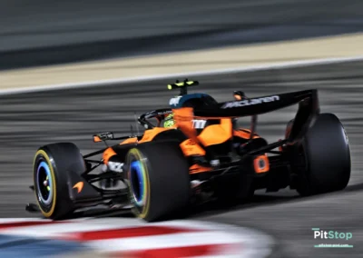 Vue rapprochée de la McLaren MCL40 de Lando Norris négociant la corde d'un virage sur le circuit de Bahreïn, mettant en avant le travail des suspensions et des pneus Pirelli.